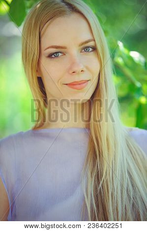 Attractive Modest Young Girl With Blond Dren Hair And Natural Make-up In Purple Dress Outdoors, Tend