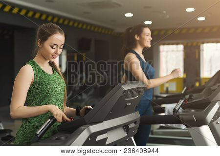 Attractive Young Woman Running On Treadmill In Gym. Slim Girl Jogging In Fitness Club. Healthy Lifes