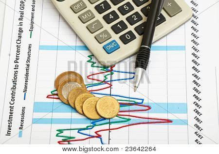 계산기, 동전과 펜 차트에 누워입니다.
