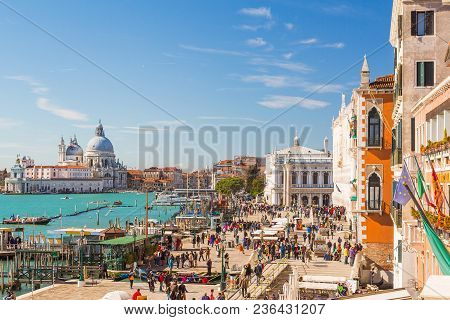 Busy Street And Square In Venice With The Laguna And View Of Grand Canal And Basilica Santa Maria De