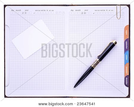 Na notebooku je pero, plastových karet a sponky