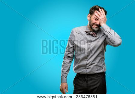 Middle age man, with beard and bow tie stressful keeping hand on head, tired and frustrated