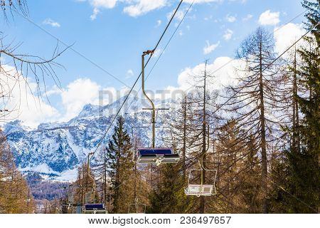 Alta Badia, Italy. March 10, 2018. Ski Lifts And Cable Car Going Up The Slopes Through Forest In Ita