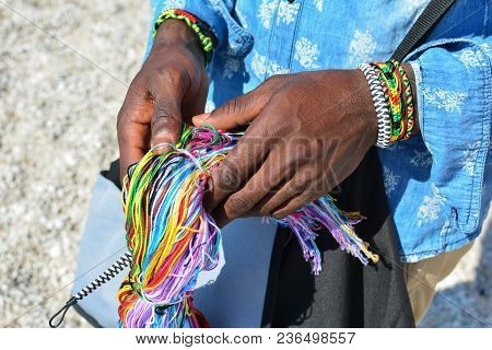 Colorful String In Black Man's Hands