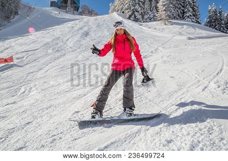 Alta Badia, Italy. November 10, 2016. Beautiful Girl Snowboarding In The Mountains Down The Slopes.