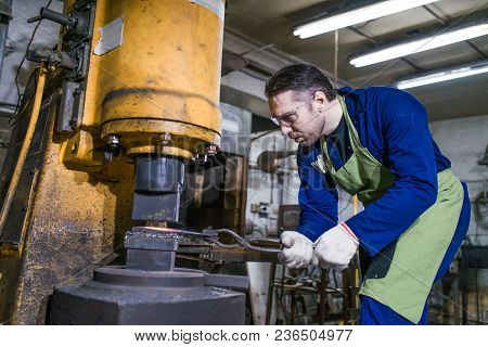 The Smith Works With An Electric Hammer.