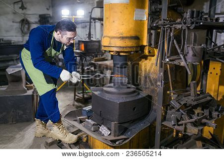 The Smith Works With An Electric Hammer.