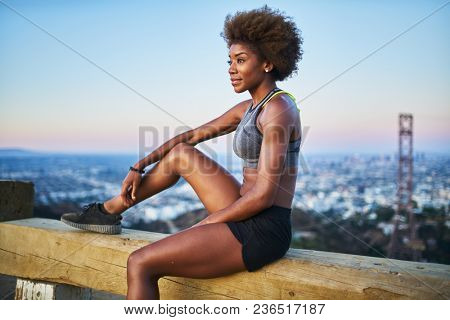 fit african woman woman resting on bench at runyon canyon shortly after sunset