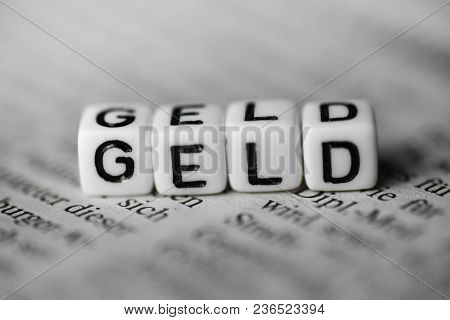 German Word Geld Formed By Wood Alphabet Blocks On Newspaper Closeup
