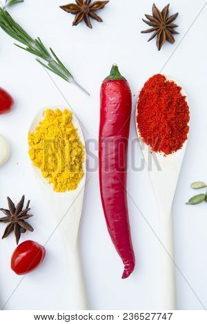 Cooking Hot Spicy Food Concept. Dry Spices And Herbs In Wooden Spoons And Chili Pepper, White Backgr