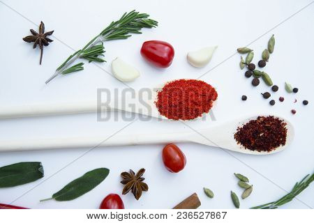 Cooking Hot Spicy Food Concept. Dry Spices And Herbs In Wooden Spoons, Fresh Herbs, Garlic Cloves An