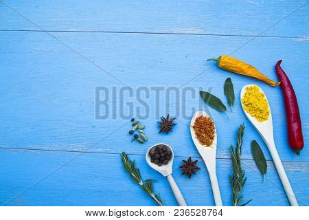 Cooking Hot Spicy Food Concept. Dry Spices And Herbs In Wooden Spoons, Fresh Herbs And Chili Peppers