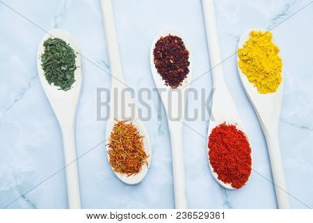 Cooking Hot Spicy Food Concept. Dry Spices And Herbs In Wooden Spoons White Marble Background, Top V