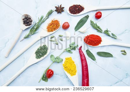 Cooking Hot Spicy Food Concept. Dry Spices And Herbs In Wooden Spoons, Fresh Herbs, Chili Peppers An