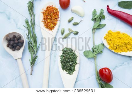 Cooking Hot Spicy Food Concept. Dry Spices And Herbs In Wooden Spoons, Fresh Herbs, Chili Peppers An