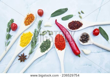 Cooking Hot Spicy Food Concept. Dry Spices And Herbs In Wooden Spoons, Fresh Herbs, Chili Peppers An