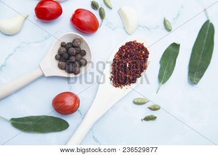 Cooking Hot Spicy Food Concept. Dry Spices And Herbs In Wooden Spoons, Fresh Herbs And Cherry Tomato