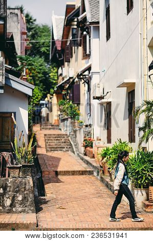 Luang Phrabang / Laos - June 29, 2010: A Girl Walking The Alley In Background