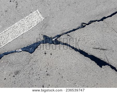 Spring Day. Asphalt Road, The Crack Is Resected With Resin. Photographed In Ukraine, Kiev. Black And