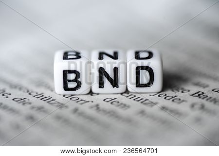 Word Bnd Formed By Wood Alphabet Blocks On Newspaper Closeup