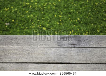 Yellow Little Flower On Green Grass With Wooden Background, Stock Photo