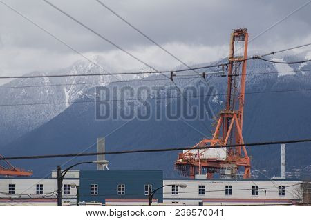 Industrial Machinery In East Vancouver With North Shore Snowy Moutains In The Background