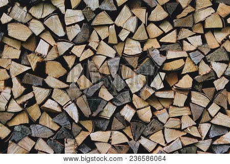 A Pile Of Stacked Firewood, Prepared For Heating The House. Firewood Harvested For Heating In Winter