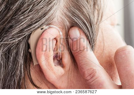 Closeup Senior Woman With Hearing Aid In Her Ear. Health Care, Hear Amplify, Device For The Deaf.