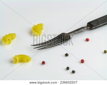 Old Vintage Fork, Uncooked Pasta Creste Di Gallo, Black, Pink And Green Peppercorns On A White Backg