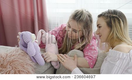 Infantile Lifestyle. Teenage Girls Holding Toy Bunnies. Youth Leisure Communication. Childish Behavi