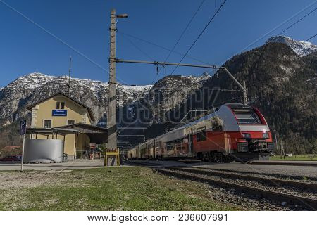 Red Electric Fast Train In Austria Alps Mountains In Sunny Spring Day