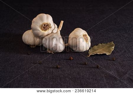 Bay Leaf, Onion And Garlic On The Textile Table Top. Dry Spices Mix