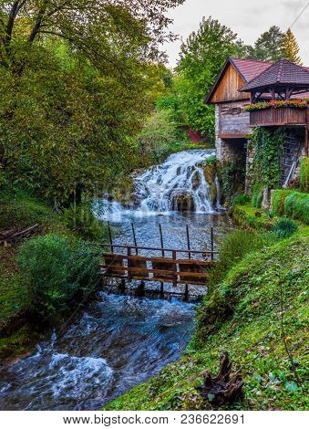 Wooden rural house over a small mill. Croatia, Slunj. Amazing park above the water channels of the Korana river. Concept of ecological and photo tourism