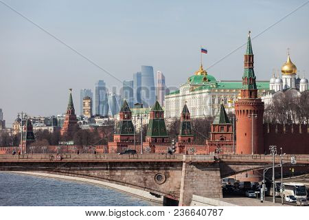 MOSCOW, RUSSIA - APRIL 5, 2018: Famous Russian historical Grand Kremlin Palace, Walls and Towers in front of modern Moscow International Business Center (MIBC) skyscrapers at Moscow City.