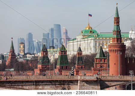 MOSCOW, RUSSIA - APRIL 5, 2018: Famous Russian historical Grand Kremlin Palace, Walls and Towers in front of modern Moscow International Business Center (MIBC) skyscrapers at Moscow City.