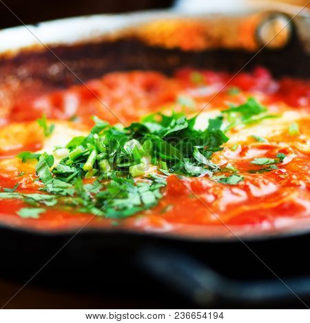 Shakshuka. Traditional Jewish Food And Middle Eastern Cuisine Recipe. Fried Eggs, Tomatoes, Bell Pep