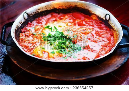 Shakshuka. Traditional Jewish Food And Middle Eastern Cuisine Recipe. Fried Eggs, Tomatoes, Bell Pep