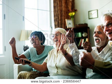 Senior people watching televison together