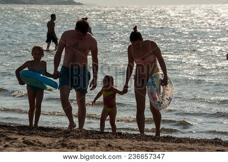 Sennoy, Russia - July 18, 2017: Taman Gulf. Silhouettes Of Family In Sea
