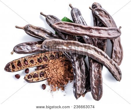 Carob pods and carob powder on the white background.