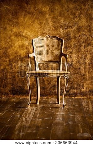 Old Chair On A Brown Wall Background