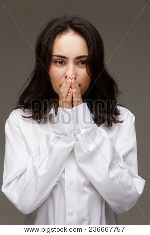 Beautiful Girl In A White Shirt Shows Emotions. On A Light Background.