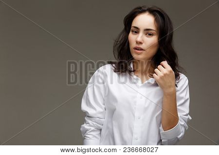 Beautiful Girl In A White Shirt Shows Emotions. On A Light Background.