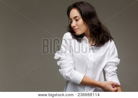 Beautiful Girl In A White Shirt Shows Emotions. On A Light Background.