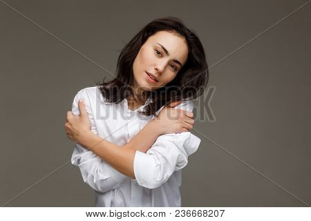 Beautiful Girl In A White Shirt Shows Emotions. On A Light Background.