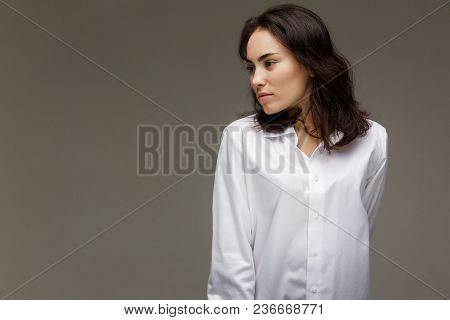 Beautiful Girl In A White Shirt Shows Emotions. On A Light Background.