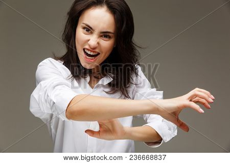 Beautiful Girl In A White Shirt Shows Emotions - Smile, Fun. On A Light Background.