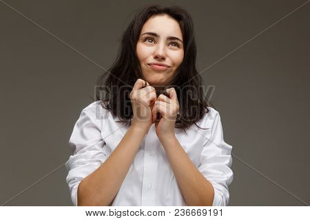 Beautiful Girl In A White Shirt Shows Emotions - Smile, Fun. On A Light Background.