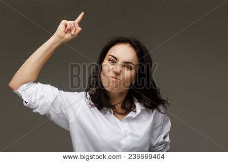 Beautiful Girl In A White Shirt Shows Emotions. On A Light Background.