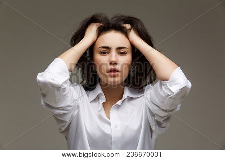 Beautiful Girl In A White Shirt Shows Emotions. On A Light Background.